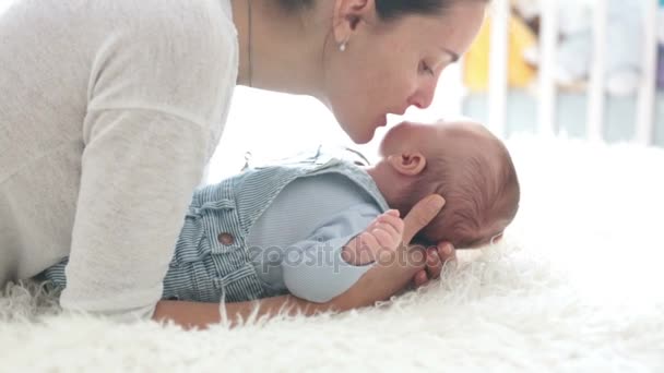 Mãe feliz, falando com seu filho recém-nascido, acariciando e beijando-o, conceito de família, mãe acariciando bebê recém-nascido — Vídeo de Stock