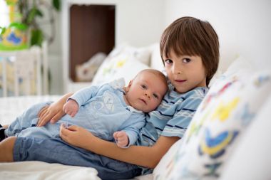 Güzel çocuk, hassasiyet ile sarılma ve onun yeni doğan Bebek Bakımı