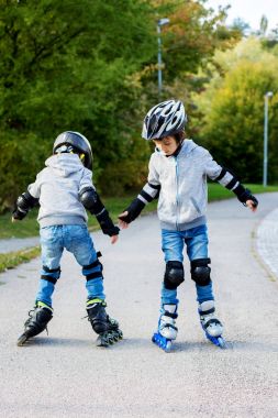 Parkta paten genç okul öncesi sevimli çocuk, erkek kardeşler,