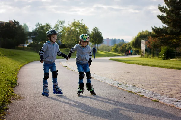 Óvodai aranyos kisgyermekek fiú testvér, korcsolyázás a parkban — Stock Fotó