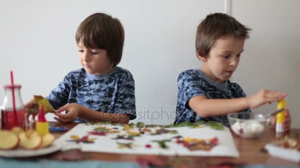 Sweet children, boys, applying leaves using glue while doing arts and crafts in school, autumn time — Stock Video