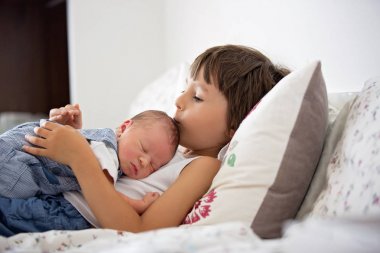 Güzel çocuk, hassasiyet ile sarılma ve onun yeni doğan Bebek Bakımı