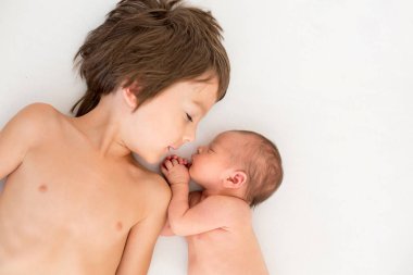 Güzel çocuk, hassasiyet ile sarılma ve onun yeni doğan Bebek Bakımı