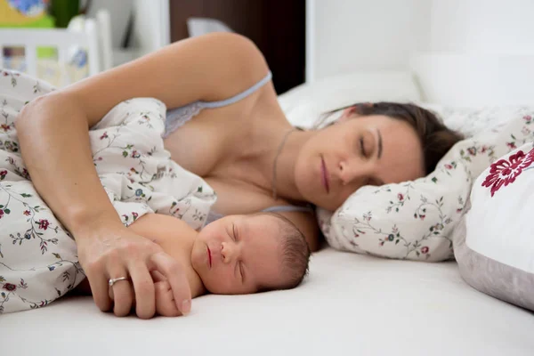 Jovem mãe dormindo com seu bebê, segurando-o — Fotografia de Stock