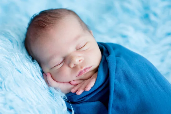 Cute baby boy, peacefully sleeping wrapped in blue wrap — Stock Photo, Image