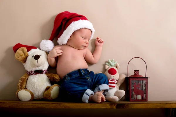 Niño recién nacido usando un sombrero de Navidad y jeans, durmiendo en — Foto de Stock