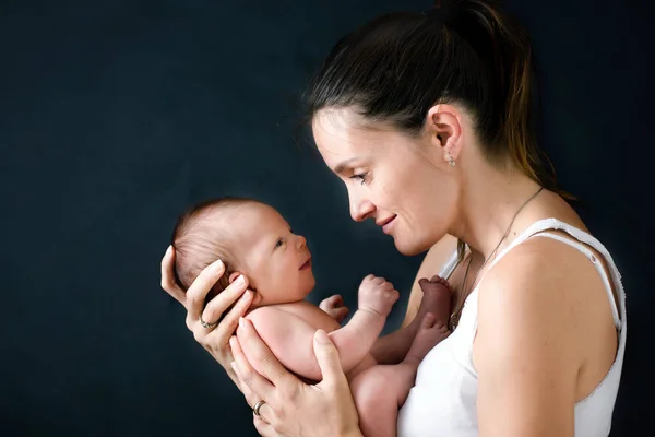 Joven madre, besando y abrazando a su bebé recién nacido — Foto de Stock