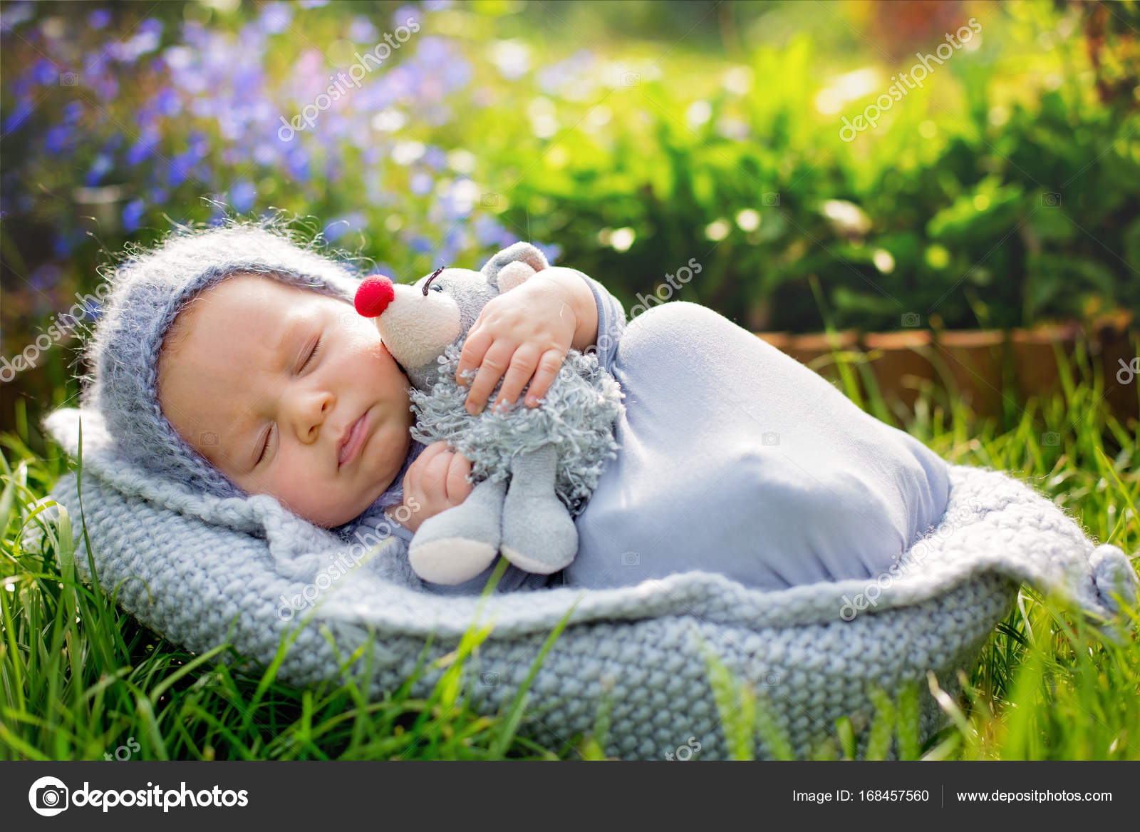 Cute little newborn baby boy, sleeping, holding cute little mous ...