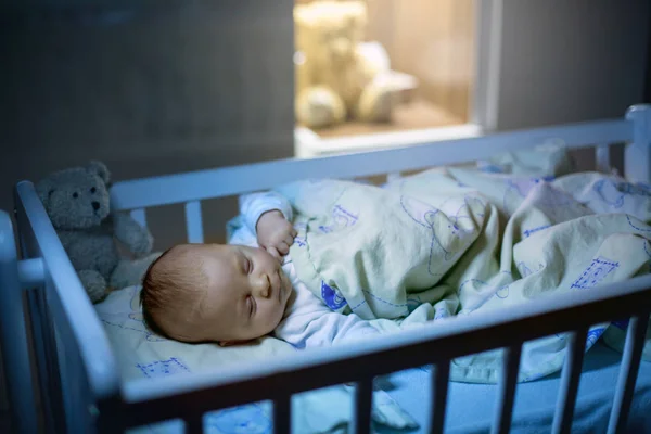 Очаровательный новорожденный мальчик, спит ночью в кроватке — стоковое фото