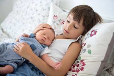 Güzel çocuk, hassasiyet ile sarılma ve onun yeni doğan Bebek Bakımı