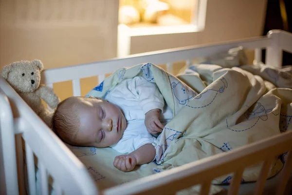Entzückender neugeborener Junge, der nachts im Kinderbett schläft — Stockfoto