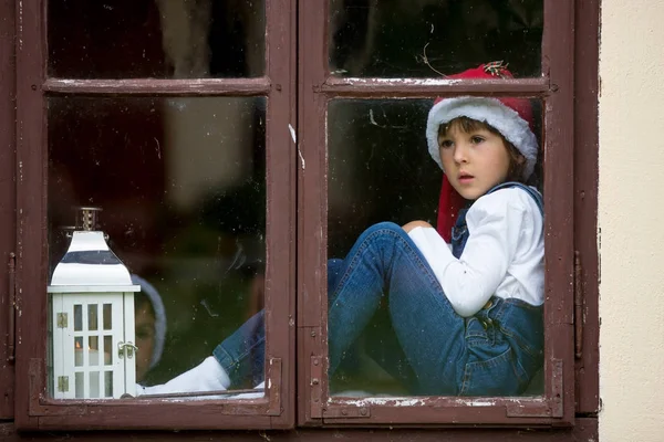 Dos chicos lindos, hermanos, mirando a través de una ventana, esperando a S — Foto de Stock