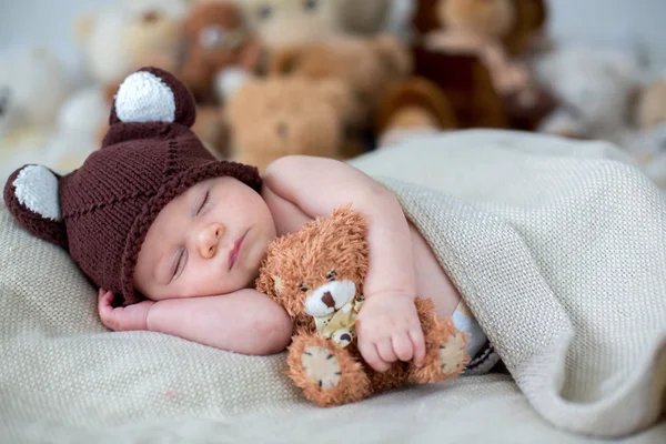 Küçük yeni doğan bebek çocuk, oyuncak ayı evde yatakta yatıyor — Stok fotoğraf