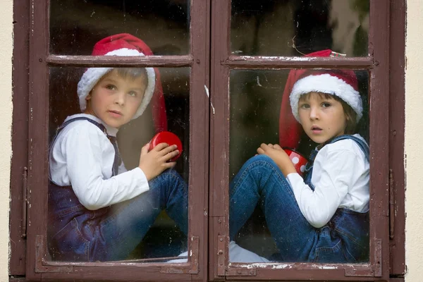 Dois meninos bonitos, irmãos, olhando através de uma janela, esperando por S — Fotografia de Stock