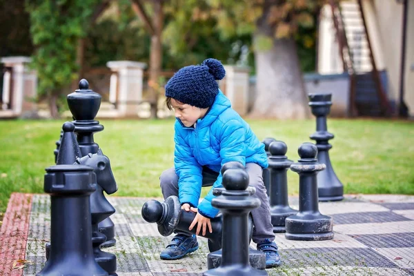 Dvě děti, chlapce bratři, hraje šachy s množstvím postav v t — Stock fotografie