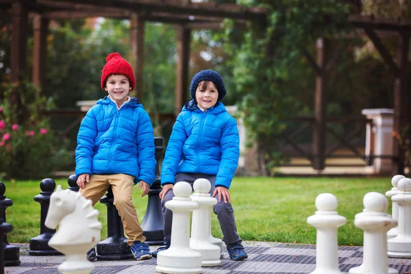 Dwoje dzieci, chłopak braci, gra w szachy z ogromnej liczby w t — Zdjęcie stockowe