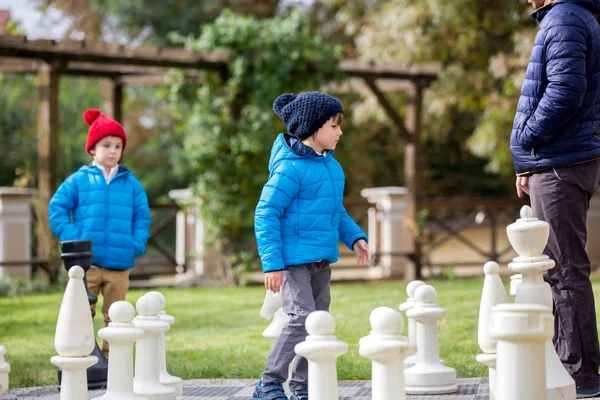 两个孩子，男孩兄弟在 t 和巨大数字下棋 — 图库照片