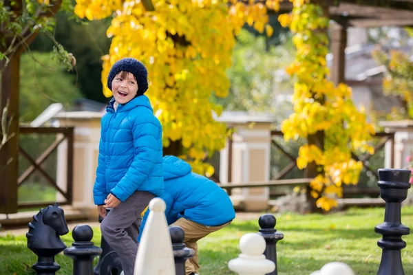 Zwei Kinder, junge Brüder, Schach spielen mit riesigen Figuren in t — Stockfoto