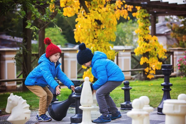 Twee kinderen, jongen broers, Schaken met enorme cijfers in t — Stockfoto