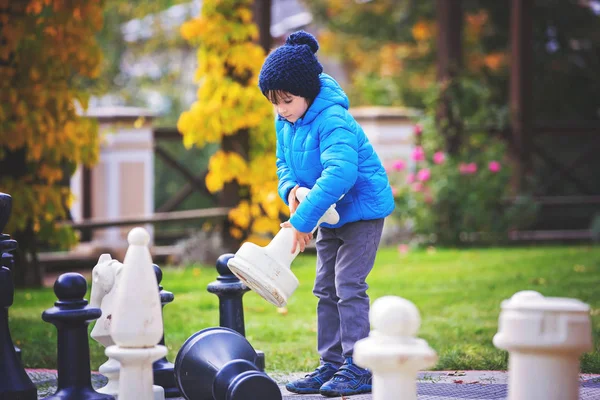 Duas crianças, meninos irmãos, jogando xadrez com grandes figuras em t — Fotografia de Stock
