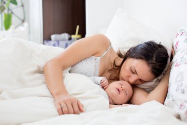 Genç anne bebeğini kucağında gözaltında, yatıyor ve