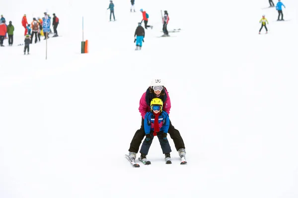 Menino doce e sua mãe, aprendendo a esquiar em um esqui suave sl — Fotografia de Stock