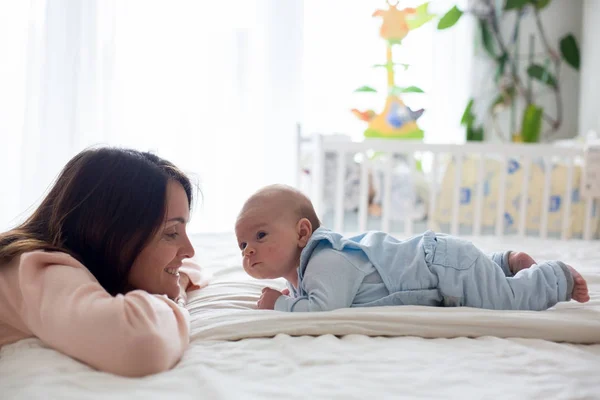 Jonge moeder haar pasgeboren babyjongen, dat ze hem in haar strelen — Stockfoto