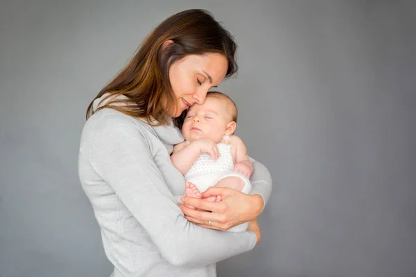 Молодая мать, ласкала своего новорожденного мальчика, держала его в руках — стоковое фото