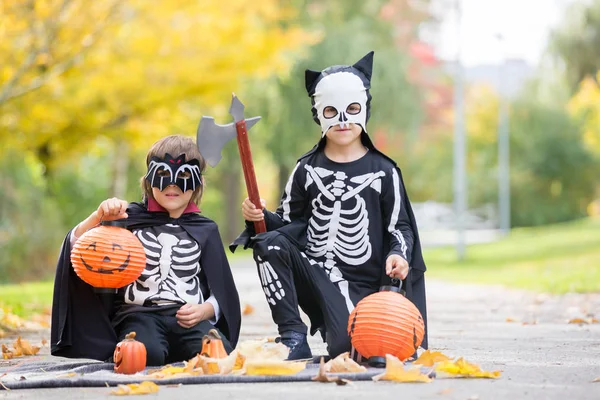 Dvě děti, chlapce bratry v parku s Halloween kostýmy — Stock fotografie