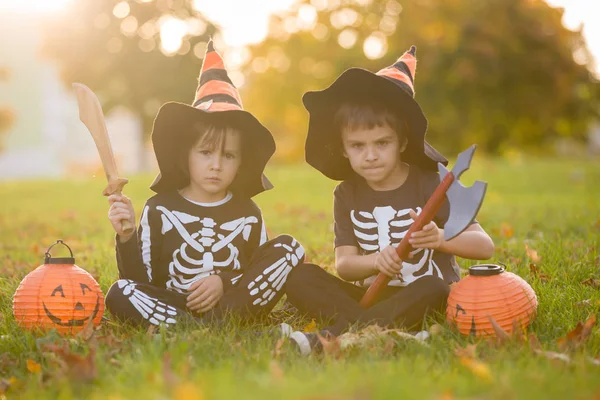 Två barn, pojke bröder i parken med Halloween kostymer — Stockfoto