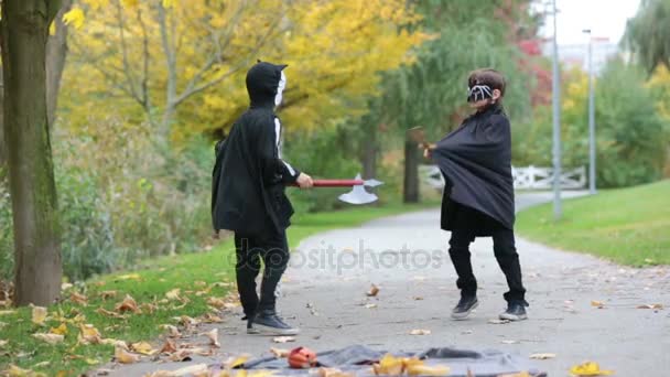 Dos niños, hermanos en el parque con disfraces de Halloween, divirtiéndose — Vídeos de Stock