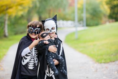 İki çocuk, çocuk kardeş Cadılar Bayramı kostümleri ile parkta