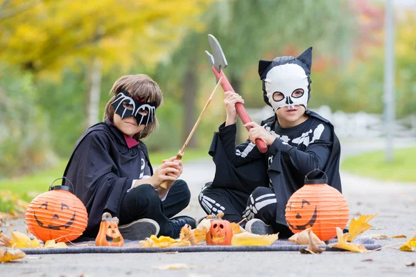 İki çocuk, çocuk kardeş Cadılar Bayramı kostümleri ile parkta