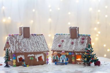 İki gösterişli evler, ağaç ve wint bir bankta oturan insanlar