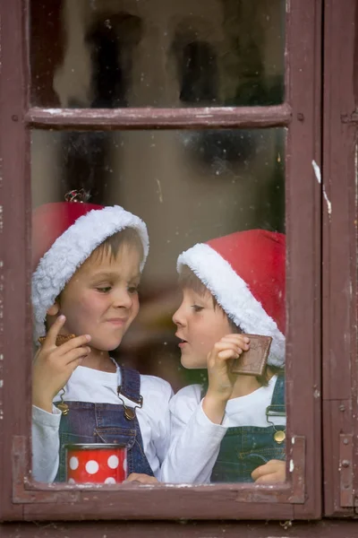 两个可爱的男孩，兄弟，透过一扇窗户，等待 S — 图库照片