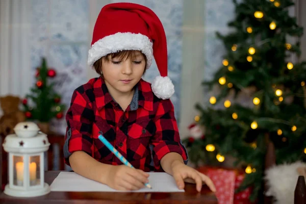 愛らしい小さな男の子が、サンタに手紙を書いて — ストック写真