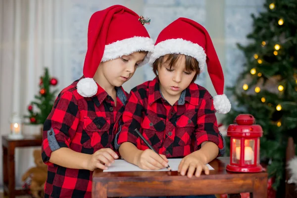 Duas crianças adoráveis, irmãos meninos, escrevendo carta ao Pai Natal — Fotografia de Stock