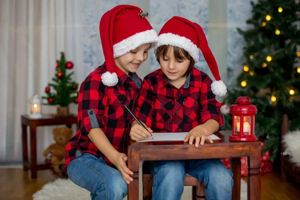 Duas crianças adoráveis, irmãos meninos, escrevendo carta ao Pai Natal — Fotografia de Stock