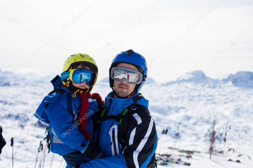 Father and son, skiing happily in Austrian ski resort in the mou