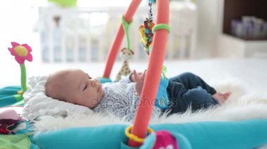 Şirin bebek çocuk ile asılı oyuncakları evde, Bebek etkinliği ve oyun geliştirme merkezi için erken bebek oynamak renkli jimnastiği. Evde oynayan çocuklar