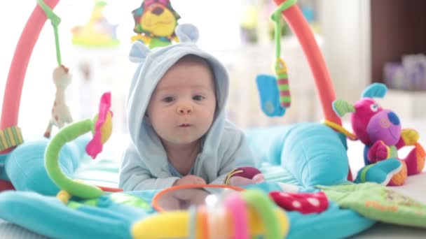 Menino bonito no ginásio colorido, brincando com brinquedos pendurados em casa, atividade do bebê e centro de jogos para o desenvolvimento infantil precoce. Crianças brincando em casa — Vídeo de Stock