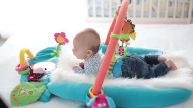 Şirin bebek çocuk ile asılı oyuncakları evde, Bebek etkinliği ve oyun geliştirme merkezi için erken bebek oynamak renkli jimnastiği. Evde oynayan çocuklar
