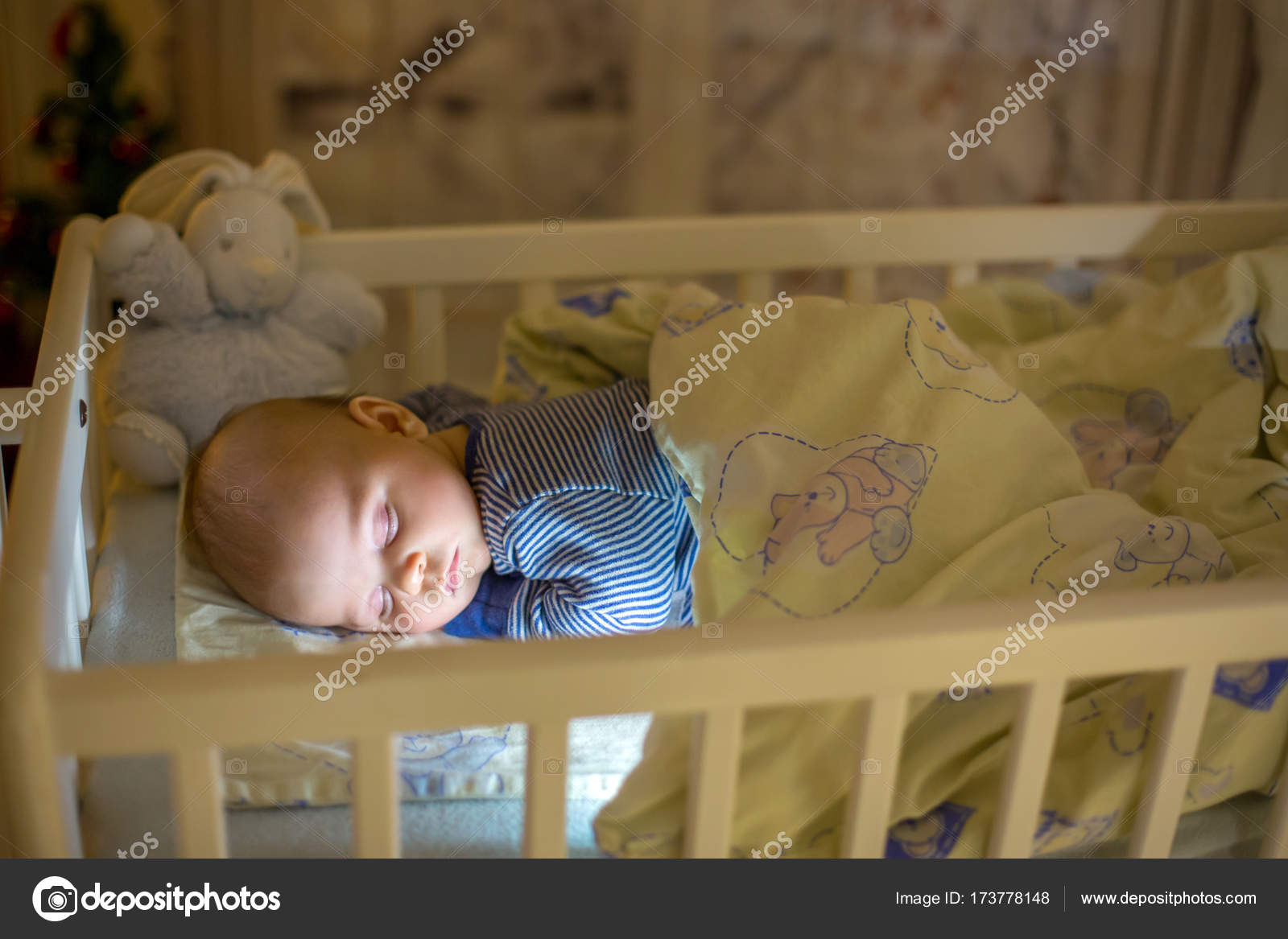 Adorable Newborn Baby Boy Sleeping In Crib At Night Stock Photo