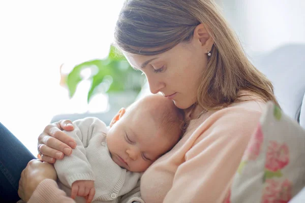 Jovem mãe, segurando ternamente seu bebê recém-nascido — Fotografia de Stock