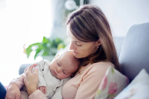 Молода мати, тримаючи ніжно свого новонародженого хлопчика — стокове фото