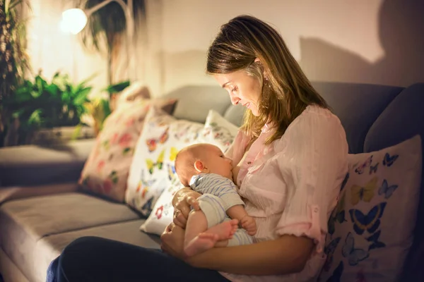 Jovem mãe bonita, amamentando seu bebê recém-nascido menino — Fotografia de Stock