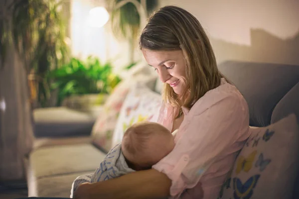 Jovem mãe bonita, amamentando seu bebê recém-nascido menino — Fotografia de Stock