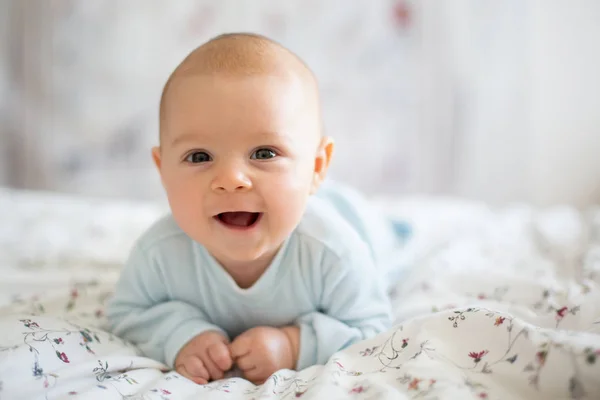 Adorable baby boy in white sunny bedroom in winter morning — Stock Photo, Image