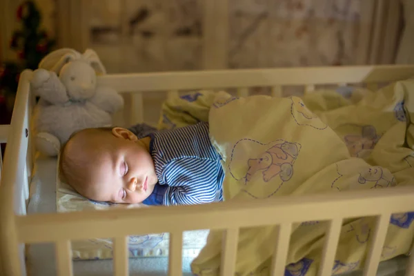 Очаровательный новорожденный мальчик, спит ночью в кроватке — стоковое фото
