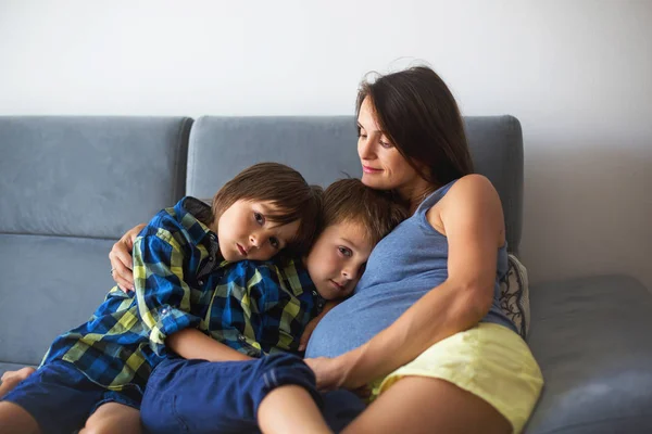 Портрет красивой беременной матери, обнимающей своих детей — стоковое фото